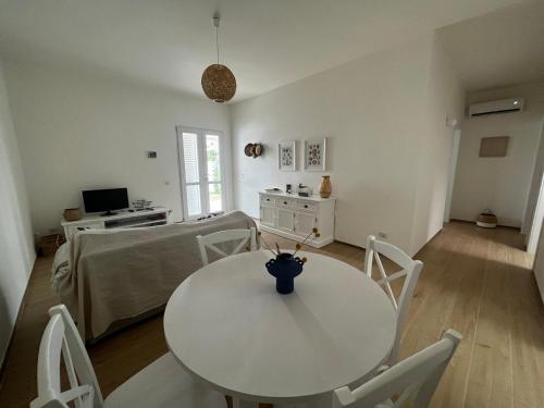 ein weißes Esszimmer mit einem Tisch und Stühlen in der Unterkunft Casa Matilde a pochi passi dal mare in Torre Squillace