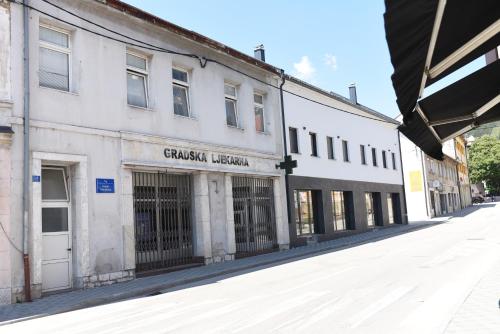 an old white building on the side of a street at Maja in Livno