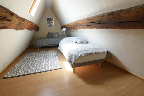 a attic room with a bed and a rug at Les Falaises de l'Estran in Dieppe