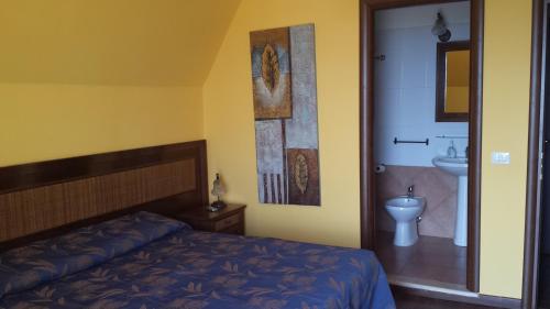ein Schlafzimmer mit einem Bett und ein Badezimmer mit einem Waschbecken in der Unterkunft Bed and Breakfast Coral Blue in Briatico
