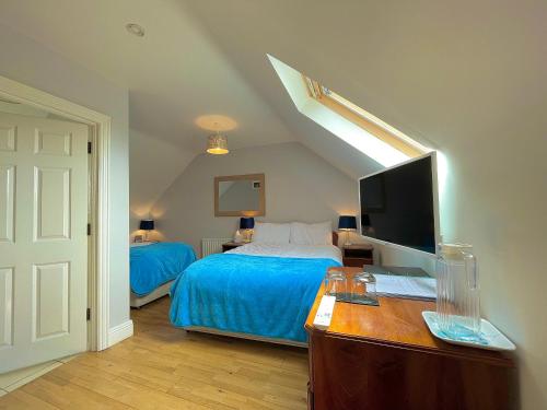 a bedroom with a bed and a desk with a computer at Whitestrand B&B in Malin Head