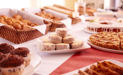 a table topped with cakes and pastries on plates at Gran Hotel Paysandú in Paysandú