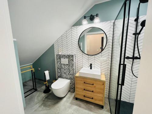 a bathroom with a toilet and a mirror at Apartament Sunnyside Rewa in Rewa