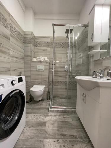 a bathroom with a washing machine and a toilet at KeSa Apartment in Korçë