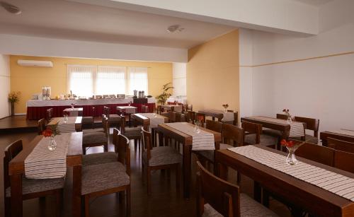 a restaurant with wooden tables and chairs and a bar at Gran Hotel Paysandú in Paysandú