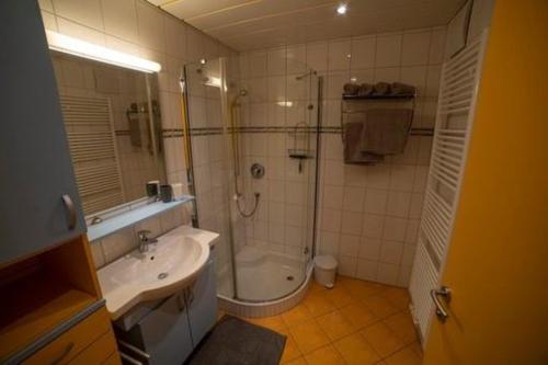 a bathroom with a shower and a sink and a tub at Ferienwohnung Laura in Wald am Arlberg