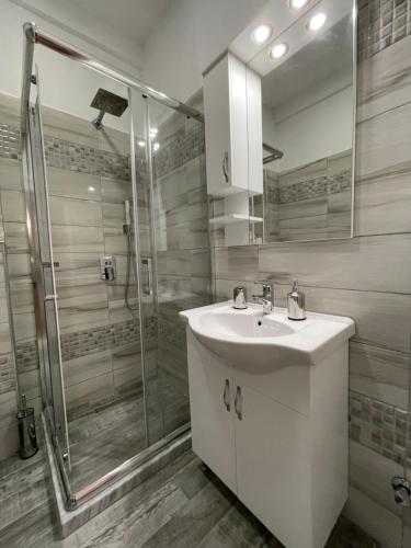 W łazience znajduje się umywalka i prysznic. w obiekcie KeSa Apartment w mieście Korcza