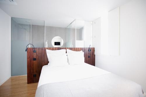 a bedroom with a white bed with a wooden headboard at Vila Real House in Vila Real