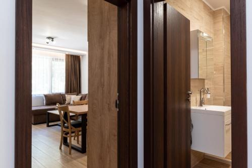 een badkamer met een wastafel en een tafel in een kamer bij Apartment ARIA in Velingrad