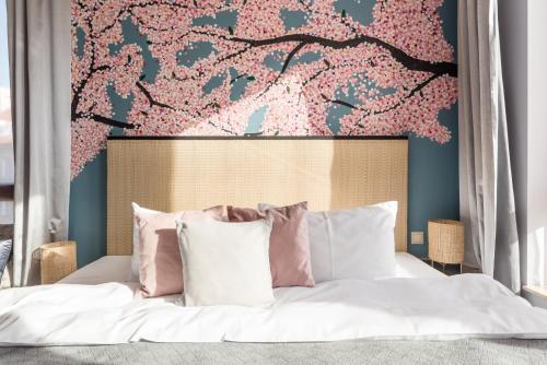 um quarto com uma cama com flores cor-de-rosa na parede em City Solei Boutique Hotel em Poznań