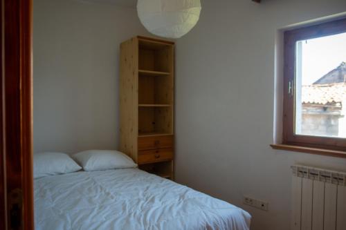 a bedroom with a bed and a window at Apartma Na skdnu in Dutovlje