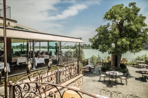 a balcony with tables and chairs and a tree at Le Ali Del Frassino in Peschiera del Garda