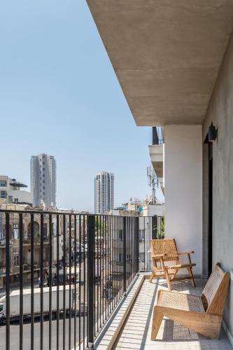 a balcony with two chairs and a view of a city at Trendy apartment next to Levinsky market in Tel Aviv
