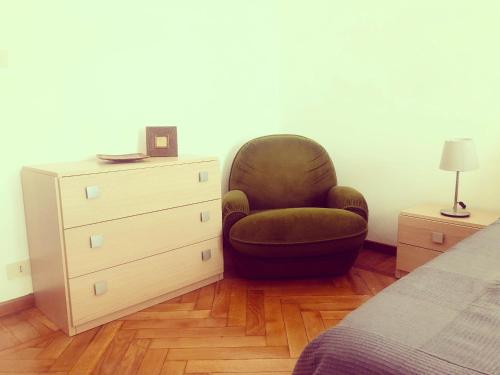 a bedroom with a chair next to a dresser at Le Affinità Selettive in Turin