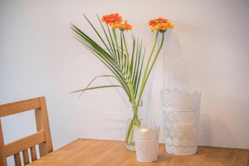 a vase with orange flowers in it on a table at Casa Lenny and Friends in Anzing