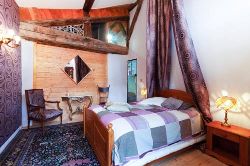 una camera con un letto e una sedia di L'Audace a Mâcot La Plagne