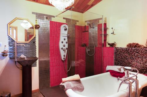 bagno con vasca e doccia con piastrelle rosse di L'Audace a Mâcot La Plagne