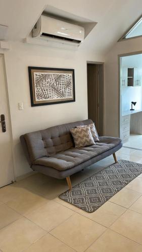 a brown couch in a living room with a rug at LD House Flora in Cali
