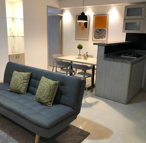 a living room with a blue couch and a kitchen at LD House Flora in Cali