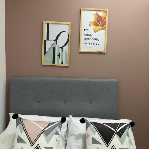 a bedroom with two pictures on the wall above a bed at LD House Flora in Cali