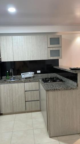 a kitchen with wooden cabinets and a counter top at LD House Flora in Cali
