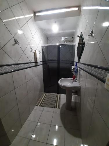 a small bathroom with a sink and a mirror at RECANTO JK in Taguatinga