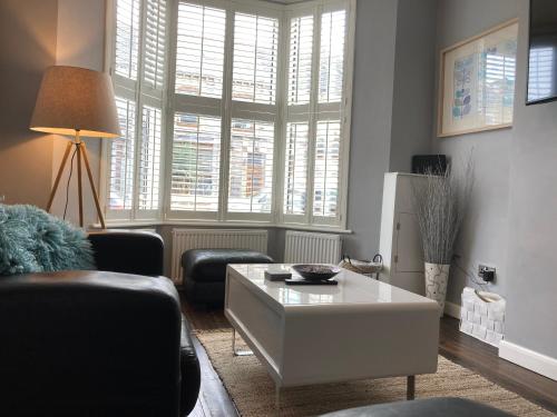 a living room with a couch and a coffee table at Tynwald Beachside Town House, West Kirby by Rework Accommodation in West Kirby