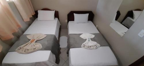a group of three beds in a small room at RECANTO JK in Taguatinga