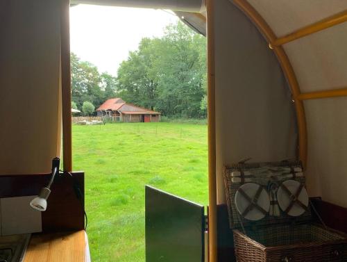 una vista del campo desde el interior de una tienda de campaña en Huifkar in landelijke omgeving, en Ureterp