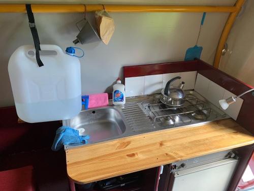 a small kitchen with a sink and a stove at Huifkar in landelijke omgeving De Mersken 9 Ureterp in Ureterp