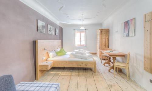 a bedroom with a bed and a desk and a table at Exclusive Apartment Tassenbacherhof in Strassen