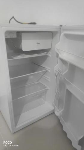 an empty white refrigerator with its door open at Pousada Blues in Ipiabas
