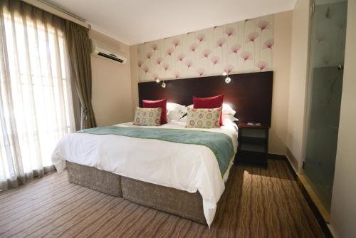 una habitación de hotel con una cama grande con almohadas rojas en Signal Hill Lodge en Ciudad del Cabo