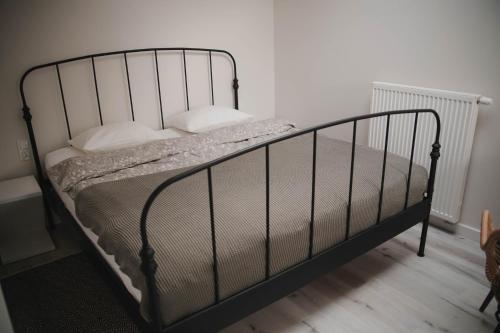 Una cama negra con almohadas blancas. en Lovely apartment Nadolnik, en Poznan