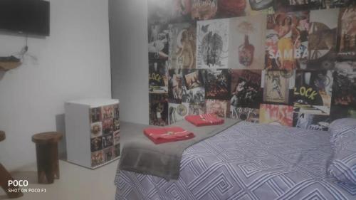 Dormitorio con cama y pared con posters en Pousada Blues, en Ipiabas
