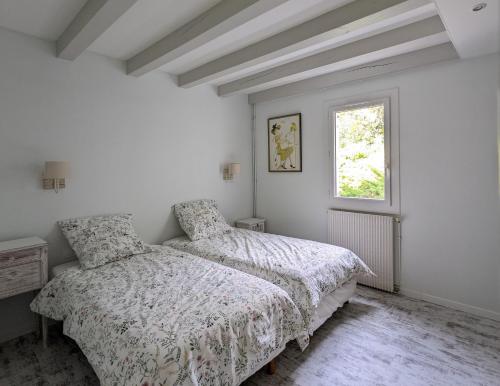 une chambre blanche avec deux lits et une fenêtre dans l'établissement Villa 'Andercool' avec piscine utilisable en toutes saisons, à Andernos-les-Bains