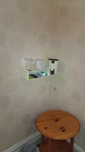a table and a shelf on a wall at Woodthorpe Hotel in Skegness