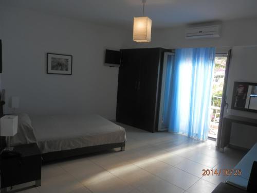 a bedroom with a bed and a sliding glass door at Glaros Hotel Apartment in Agia Galini