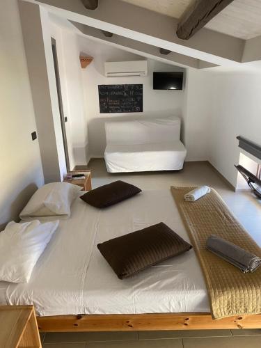 a large bed with two pillows on it in a room at Il Miglio in Più in Castel di Tusa