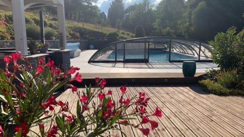 a patio with a swimming pool and a deck with flowers at Chalet l Écrin Vert in Plaine