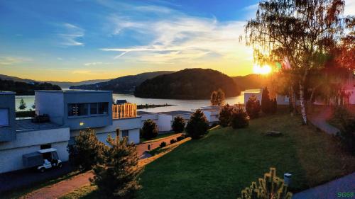 an aerial view of a house and a lake at sunset at Apartment 68 - Lemon Resort Spa in Gródek Nad Dunajcem