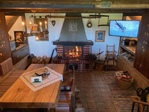 a living room with a fireplace and a table and a television at Berghütte Waldheimat in Ratten