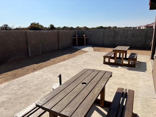 two wooden benches sitting on top of a patio at Elephant House, 2 bedroom House, Next to Pilanesberg and Sun City in Mogwase