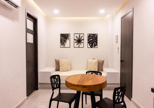 a room with a table and chairs and a bed at The Garden by DOT Suites in Santa Marta