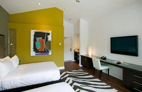 
a hotel room with a bed and a television at Truman Hotel in Key West
