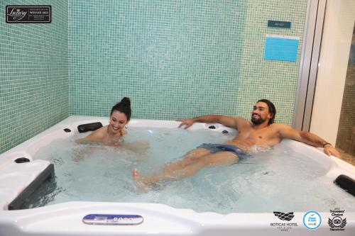 a man and a woman in a hot tub at Boticas Hotel Art & SPA in Boticas