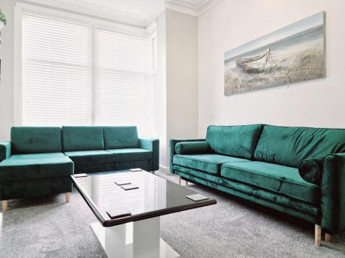 a living room with a green couch and a coffee table at DYSA Bloomfield House in Blackpool