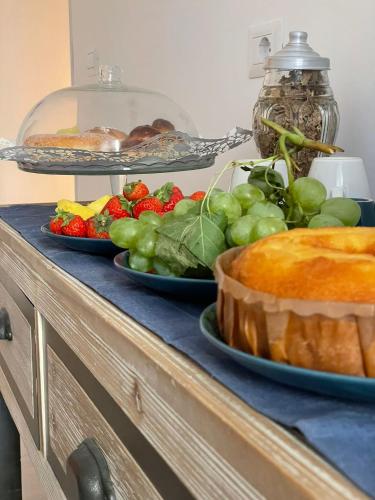 a buffet with two plates of fruit and a cake at Anfra B&B in Naples