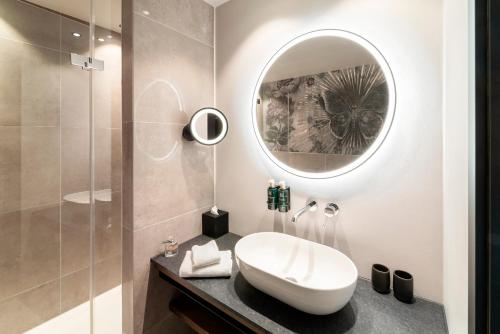 拉芬斯堡的住宿－Hotel Kaiserhof Ravensburg，一间带水槽和镜子的浴室