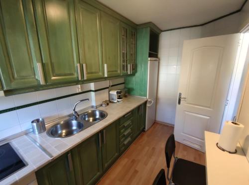 a kitchen with green cabinets and a sink at Dúplex La Vega in Cenes de la Vega